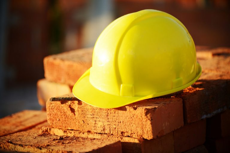 Under construction, helmet and bricks for building site